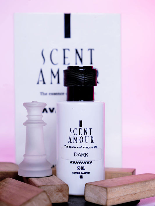 Perfume bottle labeled 'I Scent Amour Dark' with packaging on a pink background