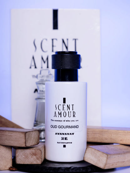 Perfume bottle with packaging labeled 'Scent Amour Oud Gourmand' on a wooden surface.